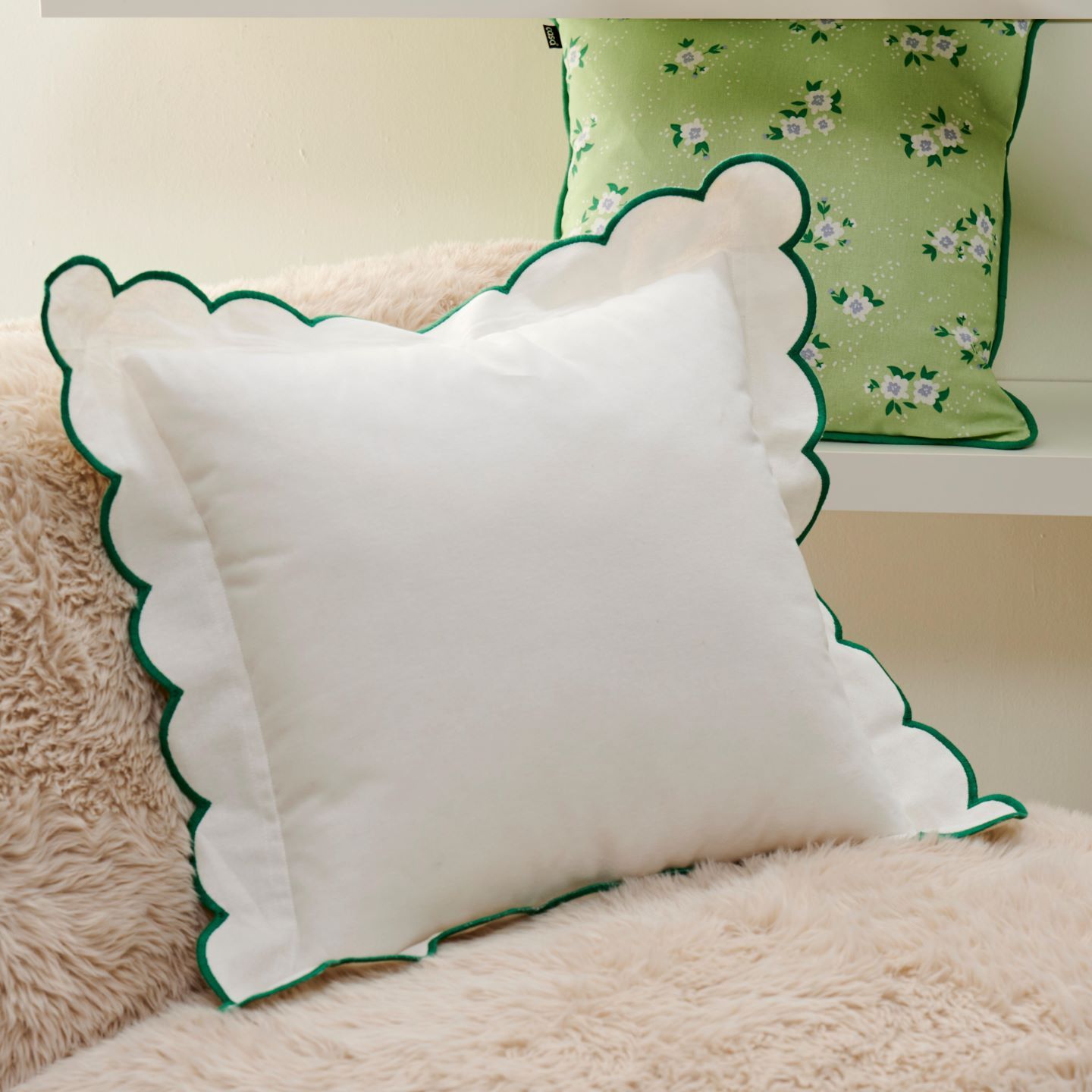 Coussin blanc festonné sur un tapis moelleux